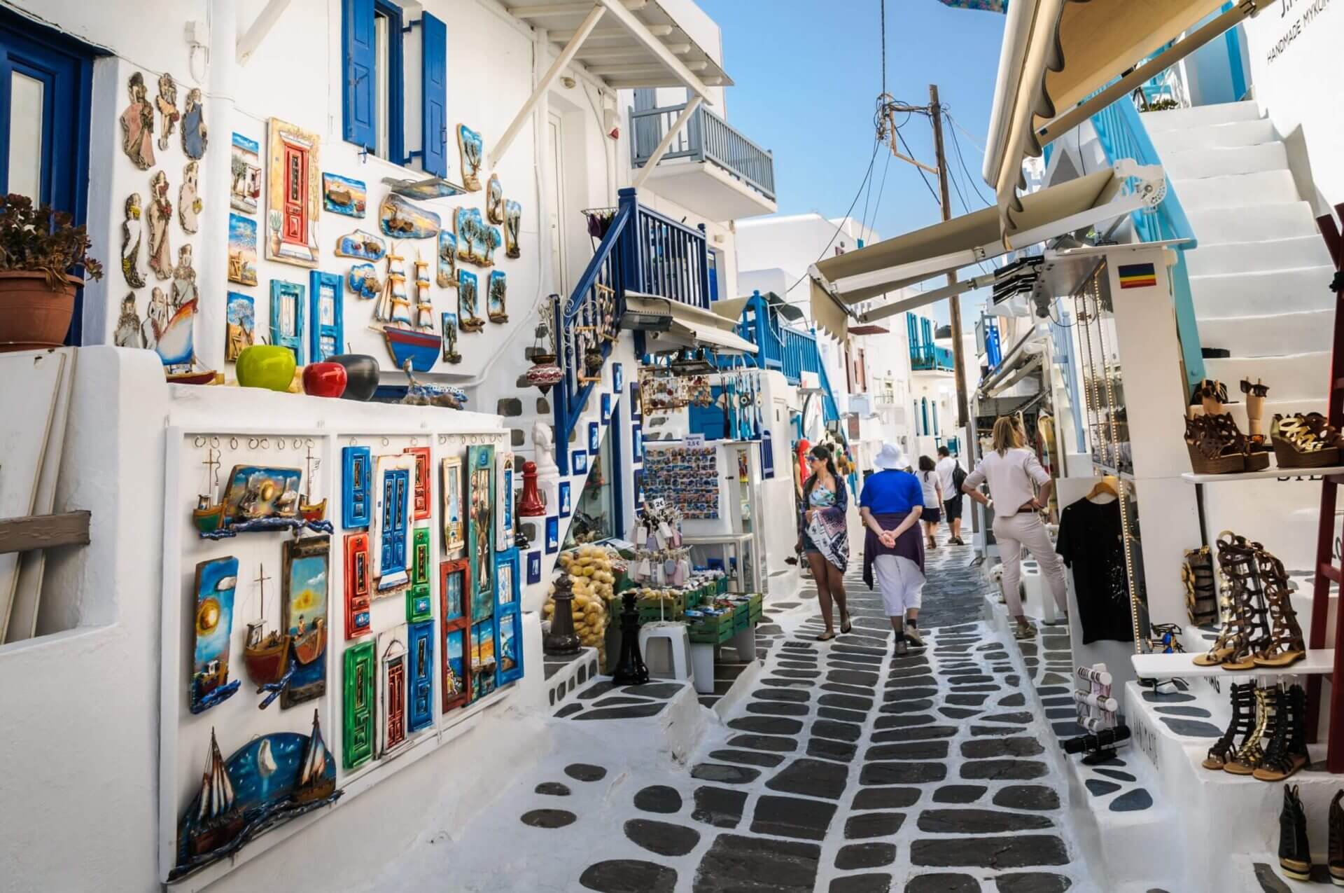 mykonos-greece-may-8-2018-shoppers-explore-the-narrow-alleys-of-mykonos-town-where-colorful-merchandise-is-displayed-in-hopes-of-catching-a-tourists-eye-stockpack-istock